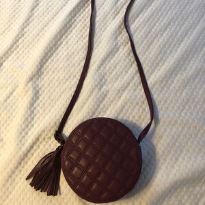 Small round burgundy over the shoulder bag with a little tassel